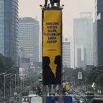Aktivis Greenpeace membentangkan spanduk kritik iklim di Patung Selamat Datang Bundaran HI Jakarta Pusat