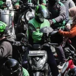 Ilustrasi pengemudi ojek online Gojek yang beroperasi di jalanan kota.