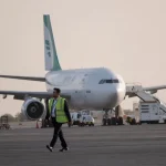 Pesawat terbang komersial sedang lepas landas dengan latar belakang langit