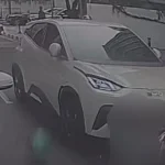 Petugas kepolisian melakukan olah TKP di lokasi kecelakaan mobil listrik yang menabrak pengemudi ojek online
