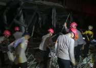 Petugas kepolisian sedang melakukan evakuasi di area reruntuhan bangunan akibat ledakan di Pasar Cimanggis, Ciputat.