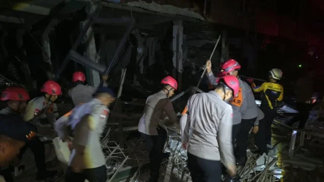 Petugas kepolisian sedang melakukan evakuasi di area reruntuhan bangunan akibat ledakan di Pasar Cimanggis, Ciputat.