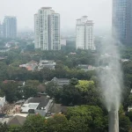 Petugas mengoperasikan perangkat water mist di salah satu gedung tinggi di Jakarta