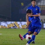 Suasana pertandingan sepak bola di stadion saat cuaca buruk