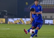 Suasana pertandingan sepak bola di stadion saat cuaca buruk